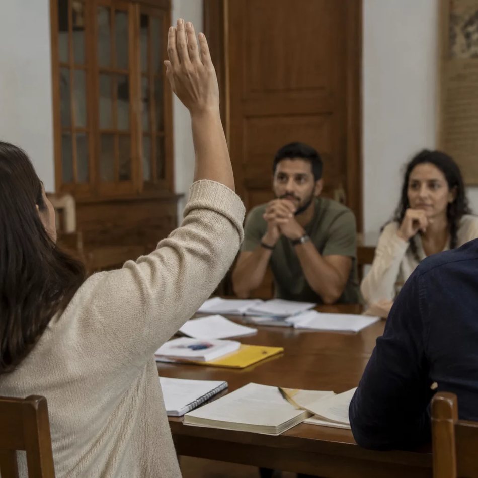 Roda de participantes; um deles repete em voz alta o argumento do colega antes de dar a resposta